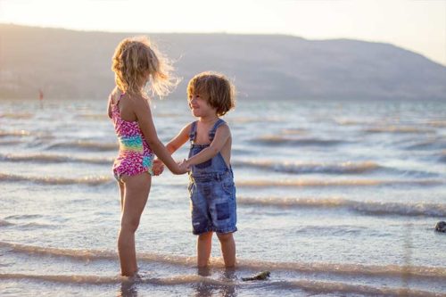 Kids holding hands at the beach