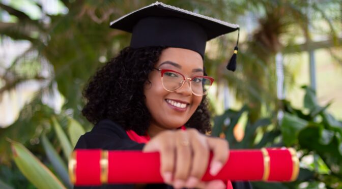 University student holding a diploma.