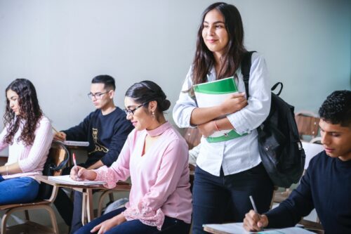 A college student is holding a notebook.