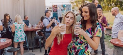 Two girls drinking at a street art festival