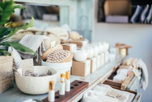 Perfume bottles placed near bath brushes and aromatic candles.