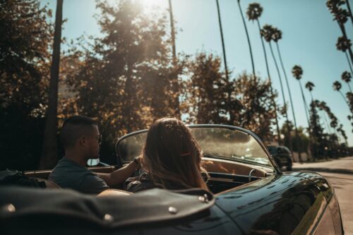 Two people in a convertible car