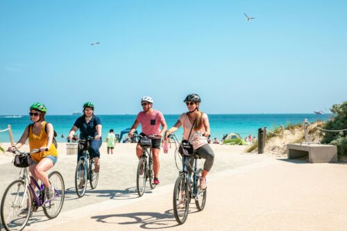 A group of people riding bicycles on a beach