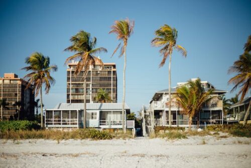Quaint beachside houses with palm trees, ideal for those seeking an ocean-view property to move to in Miami.